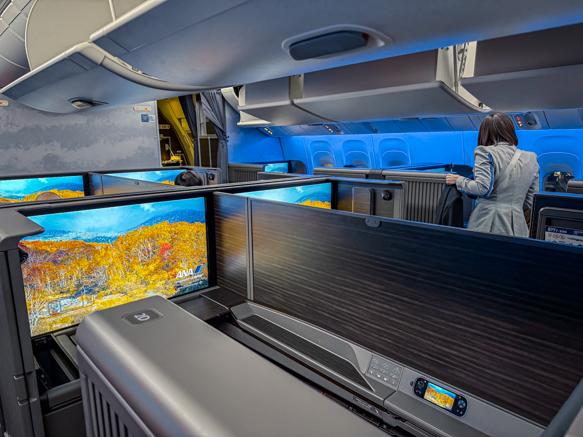 ANA First Class cabin suites with blue ambient lighting.