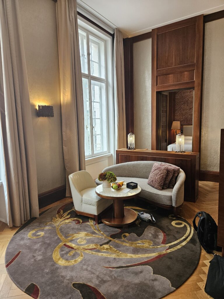 park hyatt vienna park suite deluxe living room couch chair welcome amenity desk